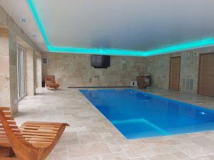Pool-house LED strip lighting creates an aquamarine hue