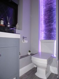 Bare brick feature wall in ensuite bathroom lit by LEDs - view 1
